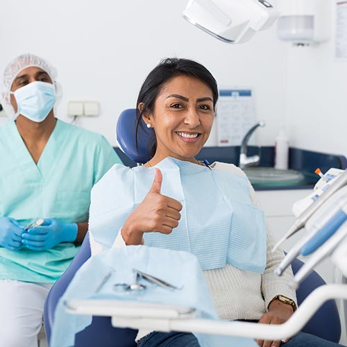 woman giving thumbs up in dental chair