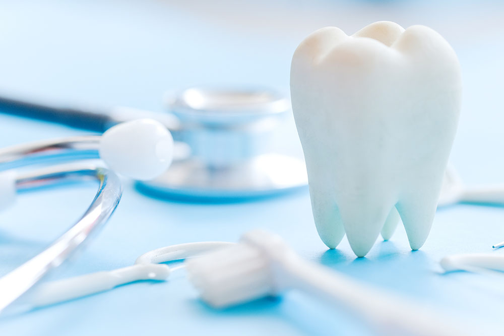 Dental model and dental equipment on blue background, concept im