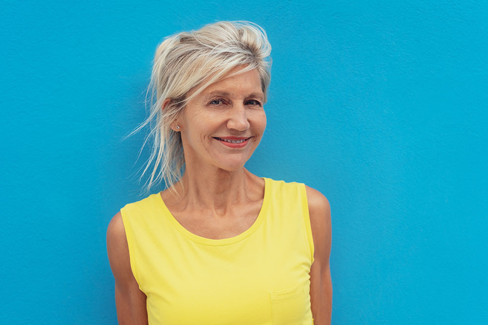 Cheerful mature woman against blue background